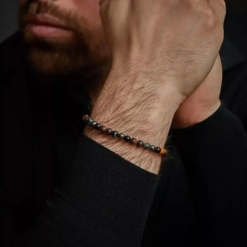 Edelsteinarmband mit grauen Perlen und Edelstahlverschluss, am Handgelenk getragen
